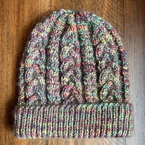 Multicolored knitted beanie on a wooden surface